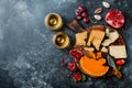 Cheese variety board or platter with cheese assortment, grapes, honey, nuts and wine in glasses. Black stone background. Top view Royalty Free Stock Photo