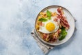 Cheese Waffles with fried bacon, egg and parmesan cheese with spices and basil for breakfast on light old concrete background.