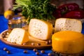 Cheese wheel on a wooden board. Blurred background
