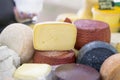 Cheese wheels different grades and cut pieces on market counter, colorful colors. Gastronomic dainty products on market