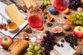 Cheese, wine, baguette grapes figs honey and snacks on the rustic wooden table top.