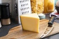 Cheese on a wooden board with a cheese knife. Kitchen interior background Royalty Free Stock Photo