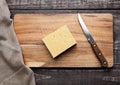 Cheese on wooden kitchen board with knife Royalty Free Stock Photo