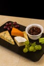 Cheeseboard platter with grapes and pickle