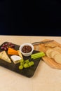 Cheeseboard platter with grapes and pickle and crackers