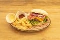 Cheeseburger, bacon, red onion, homemade fries, arugula, cheddar cheese, ketchup and mayonnaise on a colorful plate Royalty Free Stock Photo