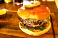 Cheeseburger In Brioche Bun On Wooden Board In Pub