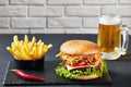 Cheeseburger, french fries, beer in a glass mug Royalty Free Stock Photo