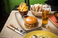 Cheeseburger with french fries and glass of beer on the table at restaurant Royalty Free Stock Photo
