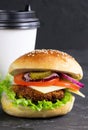 Cheeseburgers and cup of coffee on a black stone background. Hamburger with cheese. Burger isolated. Tasty Dinner.Copy space