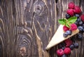 Cheesecake with berries on blue slate background.