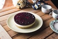 Cheesecake with berries and cups of tea on a wooden table