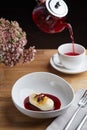 Cheesecake with berry sauce and pouring red tea on background. breakfast morning table with flowers. cottage cheese pancakes