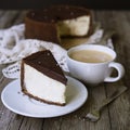 Cheesecake with chocolate and cup of coffee. Slice of classical New York cheesecake poured with chocolate sauce. Rustic