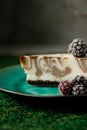 Cheesecake with chocolate flavor is on a plate with blackberries.