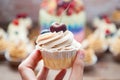 Cheesecake cupcake with cream cheese frosting and fresh cherry on top, wooden background Royalty Free Stock Photo