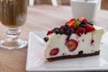 Cheesecake with fresh fruit and iced coffee in the background