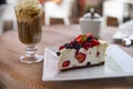 Cheesecake with fresh fruit and iced coffee in the background