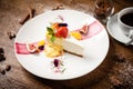 Cheesecake with passionfruit fig and orange sauce on a white plate. Delicious healthy gourmet dessert food closup served