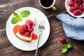 Cheesecake with raspberries and berry sauce on wooden table Royalty Free Stock Photo