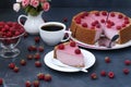 Cheesecake with raspberries is located on a dark background.