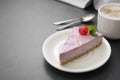 Cheesecake slice with berries and coffee cup, pink cheesecake isolated on dark background, dessert or breakfast. Sweet food