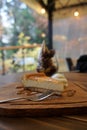 Cheesecake with syrup serving on timber block