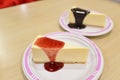 Cheesecake under strawberry sauce on white cutting board Royalty Free Stock Photo