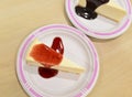 Cheesecake under strawberry sauce on white cutting board Royalty Free Stock Photo