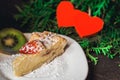 Cheesecake on Valentine`s Day with strawberry, kiwi hearts on fir and wood background