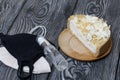 Cheesecake with white chocolate. The filling is visible on the cut. Nearby are medical masks and antiseptic. On pine planks