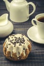 cheesecake, white creamer, teapot and cup with coffee against a