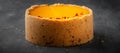 Cheesecake with yellow mango flavored layer decorated with red crumbs of freeze-dried raspberries on dark marble background. Royalty Free Stock Photo