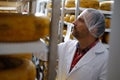 Cheesemaker checking ready product in a storage room Royalty Free Stock Photo