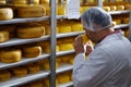 Cheesemaker checking ready product in a storage room Royalty Free Stock Photo