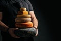 Cheesemaker holds a cheese head, Dutch cheese. dairy products on a dark background. banner, menu, recipe place for text