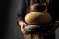 Cheesemaker holds a cheese head, Dutch cheese. dairy products on a dark background. banner, menu, recipe place for text