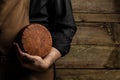 cheesemaker holds a cheese head, Dutch cheese. dairy products on a dark background. banner, menu, recipe place for text