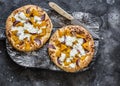 Cheesy autumn veggie flatbread. Pumpkin, sweet potato, red onion, mozzarella pizza on dark background, top view Royalty Free Stock Photo