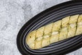 Cheesy garlic bread baton baguette with herbs on a black granite plate. Royalty Free Stock Photo