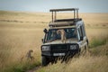 Cheetah cub watches another jump onto truck