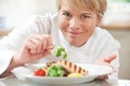 Chef Adding Garnish To Meal In Restaurant Kitchen Royalty Free Stock Photo