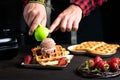 Chef adding ice cream on a waffle close up