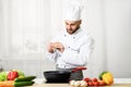 Chef Adding Pepper In A Pan Seasoning Food In Kitchen Royalty Free Stock Photo