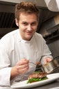 Chef Adding Sauce To Dish In Restaurant Kitchen Royalty Free Stock Photo