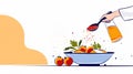 Chef adding spices and oil to a salad bowl