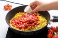 The chef adds spices, salt and sugar to the Sliced Bell Pepper, Tomatoes and Onion Pan, which is fried on the Stove. Recipe and Royalty Free Stock Photo