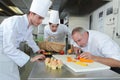 Chef and apprentices preparing food in kitchen Royalty Free Stock Photo