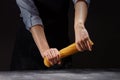 Chef in an apron breaks a handful of raw Italian spaghetti