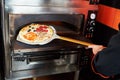 Chef baker cook taking out pizza from the oven Royalty Free Stock Photo